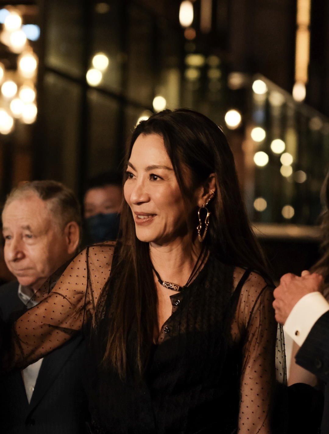 Michelle Yeoh at the Pride of Malaysia homecoming event, evening city lights behind her